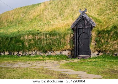 National Icelandic House with a gray door in a mountain