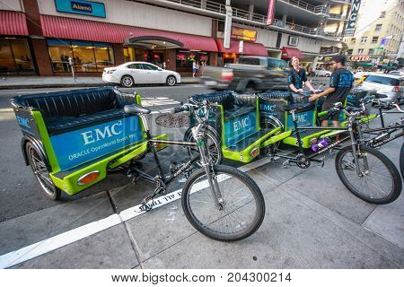 SAN FRANCISCO USA - OCT 1 2012: Unidentified young trishaw drivers wait attandees of Oracle OpenWorld conference on downtown street in San Francisco on Oct 1 2012.