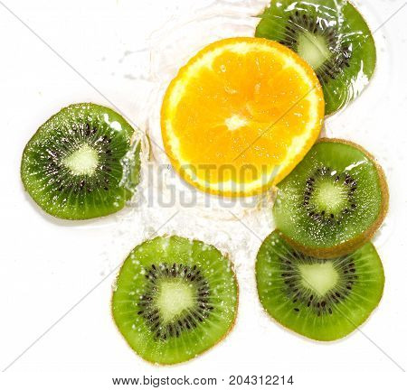 juicy kiwi and orange in water on a white background. macro