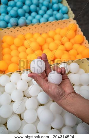 Woman hand holding two white ping-pong balls