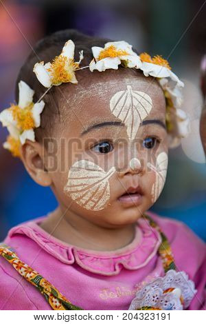 MandalayMyanmar-Fab 8 Myanmar boy show graphic of bo leaf by thanaka on your face and Flowers garland at head on the Fab 082012 in Mandalay Myanmar
