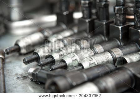 The old diesel injectors lie on the table in the fuel shop. The concept of repair of fuel diesel equipment