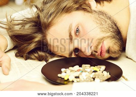 Pills On Plate Near Motionless Guy With Beard