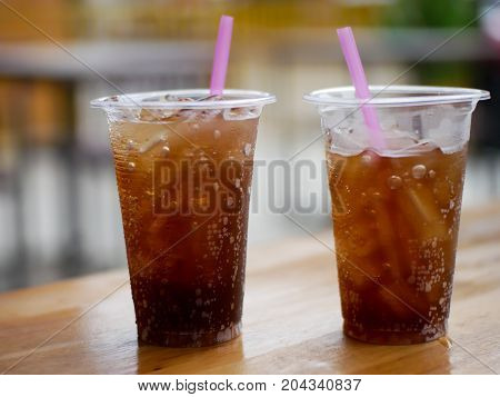 plastic cup glass of cola cola or coke on the wood table at restaurant outdoor for feel fresh