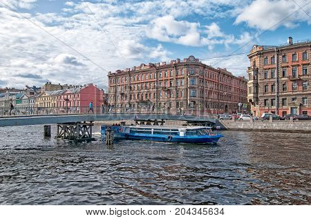 SAINT - PETERSBURG, RUSSIA - SEPTEMBER 2, 2017: People go on the wooden  Gorstkin foot Bridge over The Fontanka River. Fontanka is a popular place for water excursions