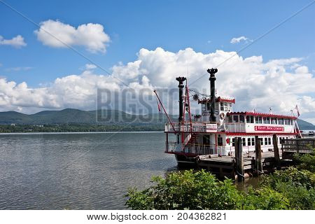 NEWBURGH NEW YORK - SEPTEMBER 15 2017. The River Rose cruise boat sits docked on the Hudson River in Newburgh New York under blue skies with white clouds and Mt. Beacon in the background.