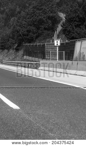 Stationary car speed radar near a highway road.