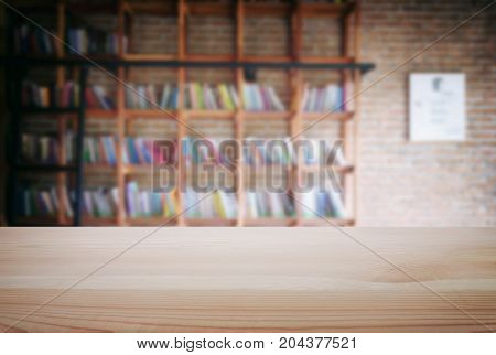 Empty wooden table and blur background of abstract in front of modern library or knowledge source can be used Mock up for display of product or for montage.