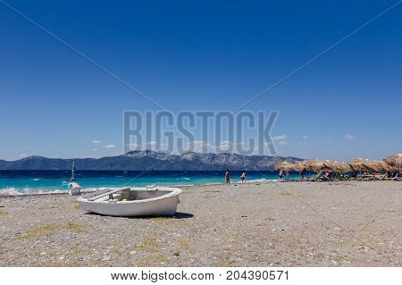 Small boat is dry docked withdrawn at the beach coastline.