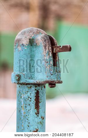 Outdoors wintage old water tap column. Street water supply.