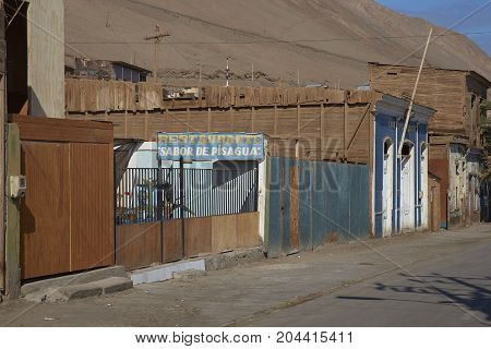 Pisagua, Tarapaca Region, Chile - August 21, 2017: Historic wooden buildings from the era of nitrate mining in the Atacama Desert, in the coastal town of Pisagua in northern Chile.