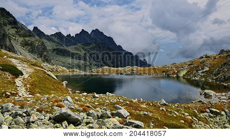 High Tatras in Slovakia. Monumental peaks. Summer scenic landscape mountain view. Alpine trail. Prostredny hrot and Starolesnianske tarn in Big cold valley.