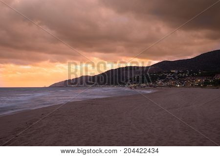 Sunset over Castelldefels beach in summer with clouds