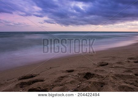 Sunset over Castelldefels beach in summer with clouds