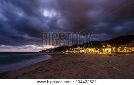 Sunset over Castelldefels beach in summer with clouds