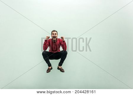 Like A Frog. Jumping Higher. Bearded Man In Red Shirt Celebrating Hes Victory, Looking At Camera And