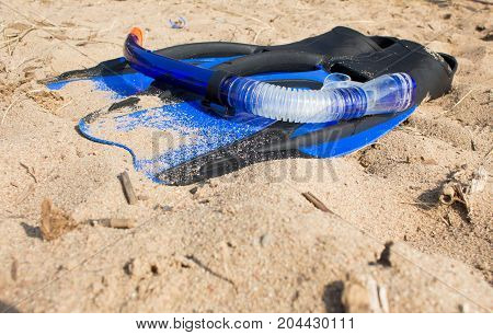 swimming snorkel and fins lying on the sand