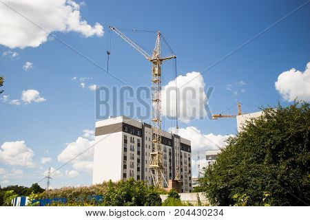 house under construction with a crane on blue sky background
