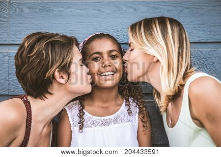 Lesbians mothers with adopted child - Happy homosexual family playing with her daughter
