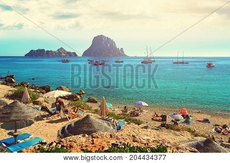 Small Cala d'Hort beach with a fantastic view of the mysterious island of Es Vedra. Ibiza Island Balearic Islands. Spain