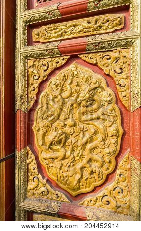 Beijing, China - Oct 30, 2016: Decorative door carving with dragon motif in relief at the Hall of Supreme Harmony (Taihedian). Forbidden City (Gu Gong, Palace Museum).