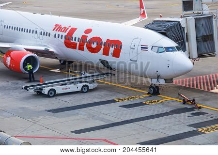 Bangkok Thailand - 14 September 2017 - Thai Lion Air aircraft waits for passengers while technician checks on the engine at Don Muang International Airport Bangkok Thailand on September 14 2017