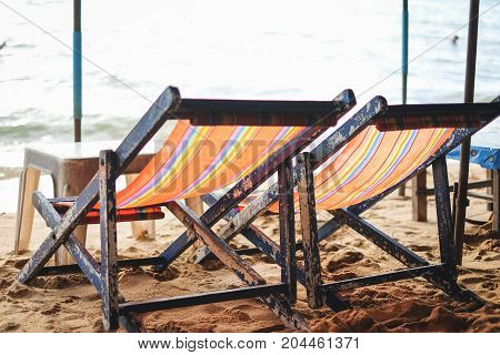 The two rainbow color deck chairs on the beach at Pattaya Thailand.