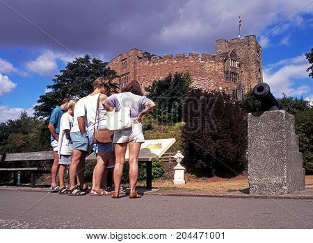 TAMWORTH, UK - AUGUST 9, 1995 - View of the Norman castle with tourists reading an information board in the foreground Tamworth Staffordshire England UK Western Europe, August 9, 1995.