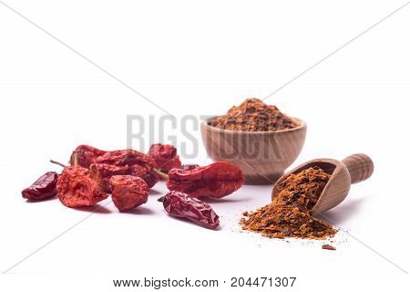 Dry chili peppers and powder on a white background