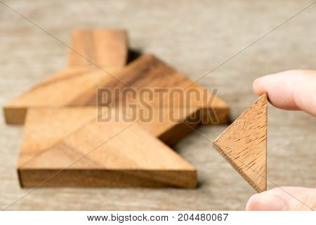 Wood tangram puzzle wait to fulfill in home shape for build dream home happy life property investment house loan concept