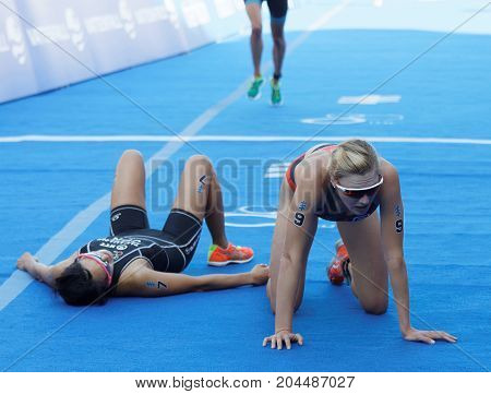STOCKHOLM - AUG 26 2017: Exhausted triathletes Takahashi and Kasper and Brown after the finish in the Women's ITU World Triathlon series event August 26 2017 in Stockholm Sweden