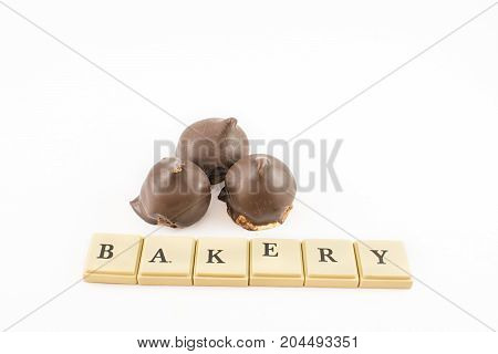 ''bakery'' written with chips and cones of dulce de leche and chocolate around. White background.