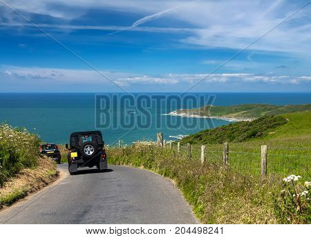 The traveler travels by car along the coast of Devon. Good sunny weather and cirrus clouds. Road near Woolacombe. England