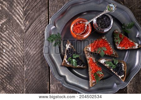 Red And Black Caviar In Small Silver Spoon On A Wood Background With Black Bread ,food Concept