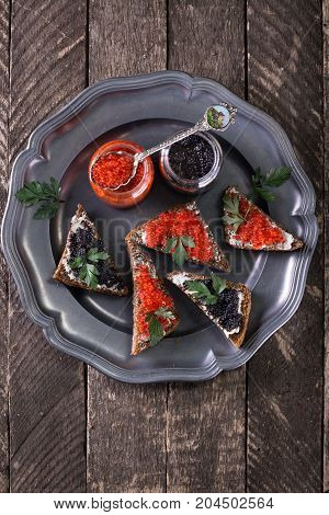 Red And Black Caviar In Small Silver Spoon On A Wood Background With Black Bread ,food Concept