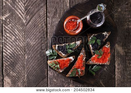 Red And Black Caviar In Small Silver Spoon On A Wood Background With Black Bread ,food Concept