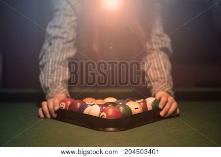 American billiard poule. Triangle of billiard balls. A man getting ready to start a game of billiards.