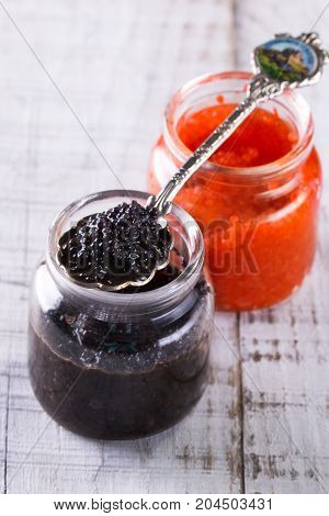 Red And Black Caviar In Small Silver Spoon On A Wood Background With Black Bread ,food Concept
