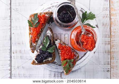 Red And Black Caviar In Small Silver Spoon On A Wood Background With Black Bread ,food Concept