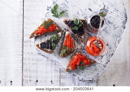 Red And Black Caviar In Small Silver Spoon On A Wood Background With Black Bread ,food Concept