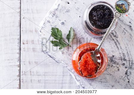 Red And Black Caviar In Small Silver Spoon On A Wood Background With Black Bread ,food Concept