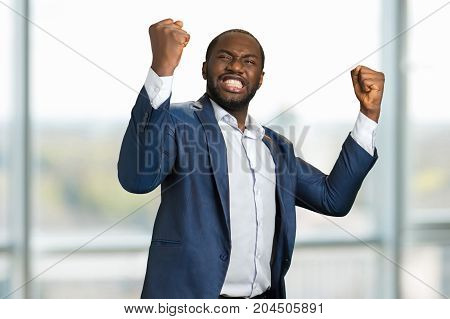 Businessman with clenched fists and teeth. Young manager clenching teeth and raised fists. Concept of great businessman achievement and victory.