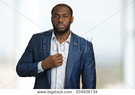 Serious businessman hold hand on chest. Portrait of confident entrepreneur with squinty look. Businessman on style.