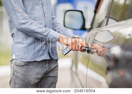 A young guy opens the door to a used car. Used car theme.