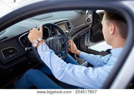Young family comes into car dealership to choose the car to buy it.
