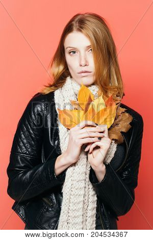 Woman With Autumn Leaves In Leather Jacket And Scarf