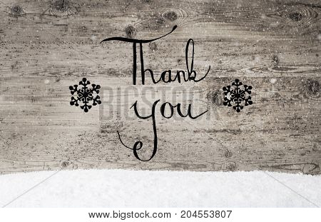 Black English Calligraphy Thank You. Rustic Wooden Background With Snow