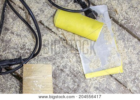 Yellow Abrasive paper on wooden background, top view
