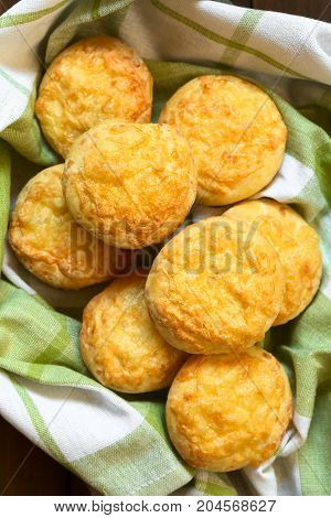 Hungarian traditional Cheese Pogacsa savory baked bread-like pastry on fabric photographed overhead with natural light (Selective Focus Focus on the top pastries)