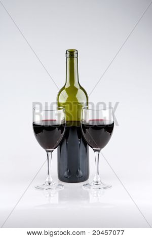 Twee glazen van rode wijn met groene fles